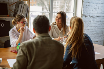 Analysis. Group of young business professionals having a meeting. Diverse group of coworkers discuss new decisions, plans, results, strategy. Creativity, workplace, business, finance, teamwork.