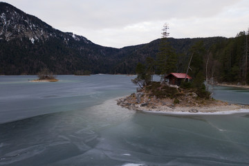 Eibsee mit Hütte mit roten Dach gefroren