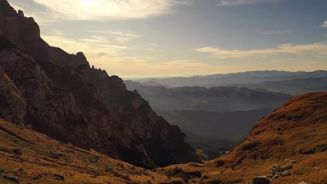 Aerial drone 4k clip of beautiful sunset showing a huge mountain valley in Bucegi mountains, during magical golden hour light in autumn season
