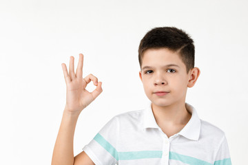 cute little boy in t-shirt making Ok gesture on white background.