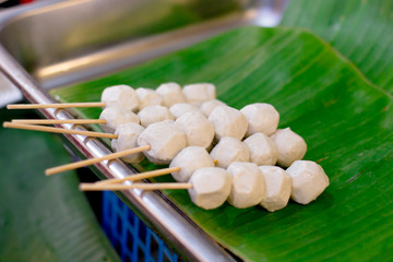 pork balls are placed on a tray with banana leaves.