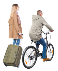 Obraz premium Back view of couple in winter jacket. man on a bicycle and a woman.