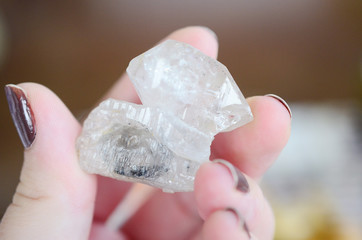 Woman holding clear quartz, beautiful healing crystal. Witches crystal healing, bright white...