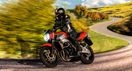 red motorcycle on the country road riding through curve. biker enjoys fun to ride the zigzag serpentines