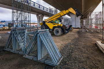Forklift on a construction site, preparing to raise construction parts