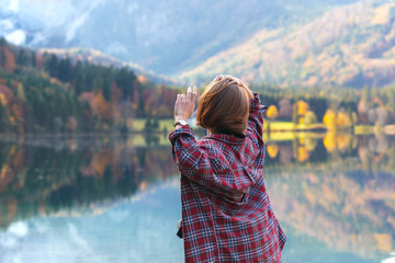 Fototapeta na wymiar girl stands on the shore of a mountain lake