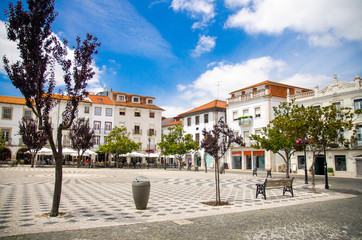 Fototapeta na wymiar Portugal, view of the main square of the old town Leiria with red tile of roofs, paving portuguese streets, nice clear summer day with air blue sky in Portugal city