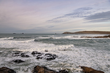 soft afternoon skies over waves and Cornish headland