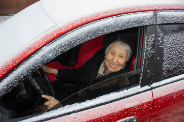 Active senior woman - smiling retired lady driving car
