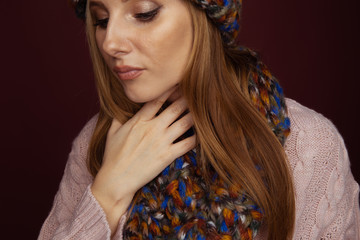 Closeup picture of woman in winter clothes holding her throat and feeling pain in it