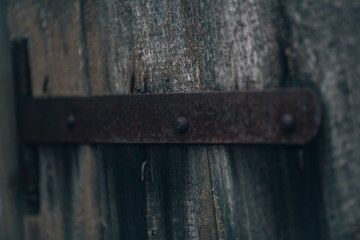 Antique iron door hinge, defocused blured photo. Vintage door element on old rotten wood