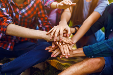 Young people putting their hands together. Teenagers having fun together in summer park. Group of young people enjoying party. Rest, fun, summer, holidays concept.