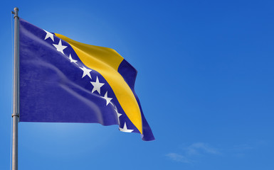 Bosnia Herzegovina flag waving in the wind against deep blue sky. National theme, international concept. Copy space for text.