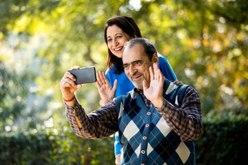 Senior woman sharing media content with her husband using mobile phone