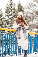 Young brunette woman in white down jacket in winter street