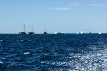 View of wavy sea and ships on the horizon