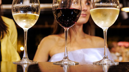 Close-up of three glass with wine on foreground.