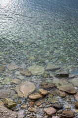 abstract sea background with water covering stones and pebbles. Vertical orientation