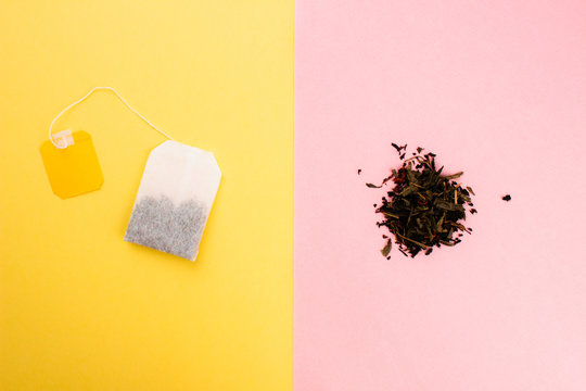 Tea Bag And Loose Leaf Tea Flat Lay On Colorful Trendy Yellow And Pink Backgrounds. Top View Copy Space. Tea Bag Or Loose Leaf Tea Waste And Recycle Concept. Creative Design For Articles. Stock Photo