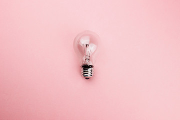 Glass transparent lightbulb flat lay on colorful pink background. Top view copy space. Creative fashion design in minimal style. Ecology, energy power, idea concept. Template for web. Stock photo.