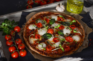 homemade pizza with ingredients, top view on dark stone table, food consept