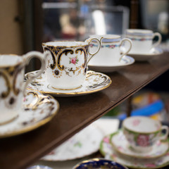 the multicolored tea and dining sets at a flea market for sale