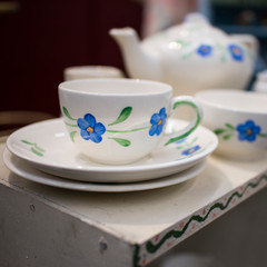 the multicolored tea and dining sets at a flea market for sale