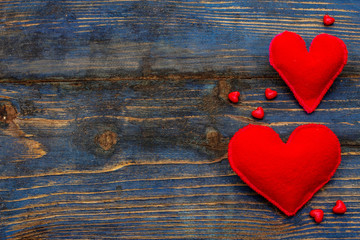 Love concept for Valentines day or mothers day. Card with space for text. Red felt hearts, beads, old wooden boards background