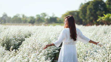 Portrait image of an asian woman walking into a beautiful Cutter flower field - Powered by Adobe