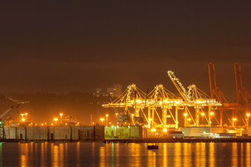 Fototapeta na wymiar Cranes at Port of Seattle terminal at night, Washington, USA