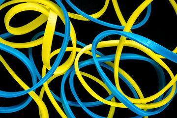 pile of colorful small rubber bands isolated on a black back ground