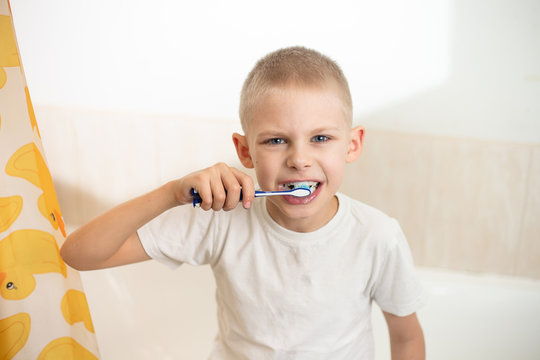 cute cute boy of 8-9 years old with a wide smile brushes his teeth