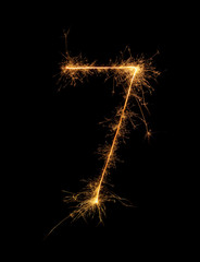 Digit 7 or seven made of bengal fire, sparkler fireworks candle isolated on a black background....