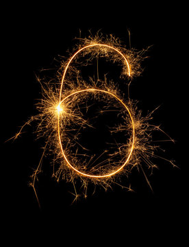Digit 6 or six made of bengal fire, sparkler fireworks candle isolated on a black background. Party dark backdrop.