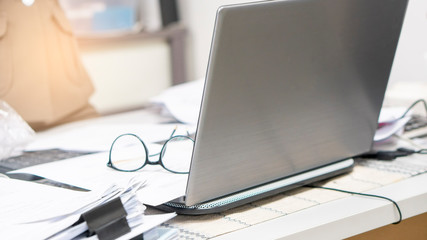 Business office desk concept.Stack of paper,desktop laptop and annual report placed on table.