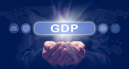 Businessmans cupped hands holding an GDP business concept on a computerised display.