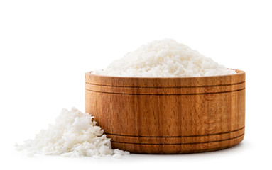 Coconut shavings in a wooden plate close-up on a white background with. Isolated