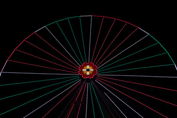 carnival Ferris wheel carousel entertainment object holidays festive time circle shape construction with red and white illumination at night time black background empty copy space