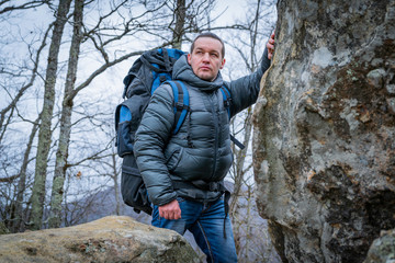 Tourist on the peak of high rocks. Sport and active life concept