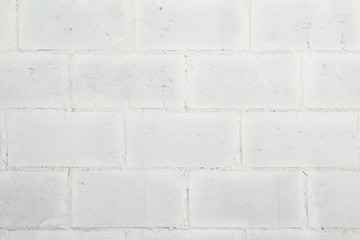 White wall made of large painted brick.