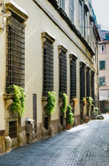 Street of the old town of Italy, with beautiful window sills with medieval wrought iron bars