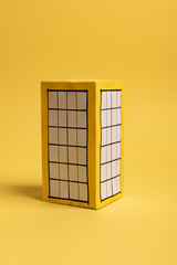 Yellow paper block of flats on yellow background paper. Minimalistic and simple concept, style. Copy space. Horizontal orientation.