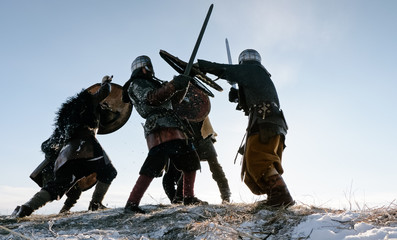 Warriors of vikings are fighting during attack at winter time.