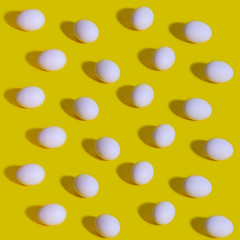 Pattern of white eggs on a pastel yellow background. Easter template