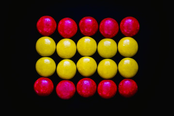 playing with colorful candy coated chocolate buttons on a black background