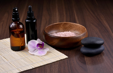 Spa and wellness setting with cosmetic accessories stock images. Massage stones with orchid stock images. Spa-concept with zen stones, orchid flower, cosmetic bottles and salt