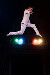 side view of flexible air acrobat flying in arena of circus