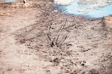 Fototapeta na wymiar Dirty bike tracks on the ground in springtime.