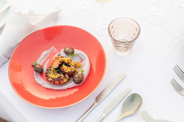 Gourmet food on elegant background. Luxury restaurant closeup. Grilled octopus on white plate served with white wine , top view. Seafood.