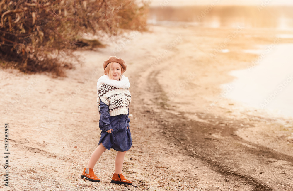 Wall mural cute little girl in autumn clothes outdoors